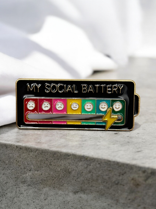 My Social Battery brooch in black with faces and a yellow lightning bolt