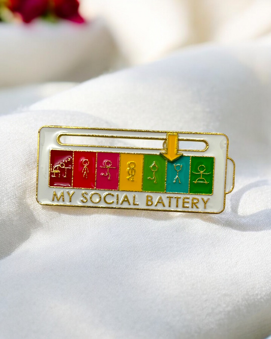 My Social Battery brooch in white with a figurine and yellow arrow