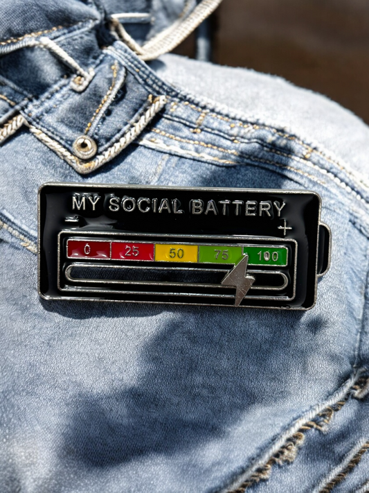 My Social Battery brooch in black with numbers and a white lightning bolt